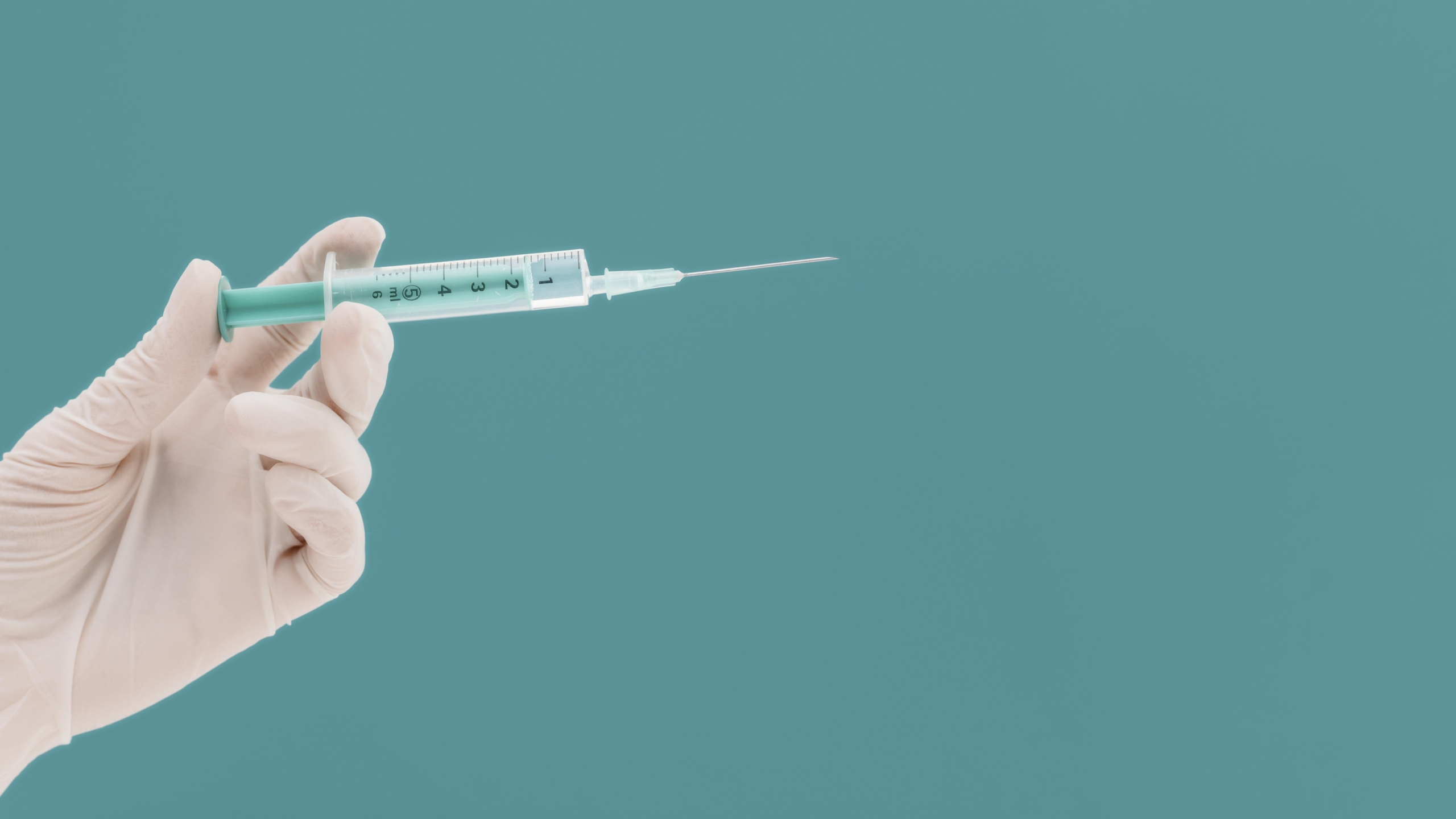 syringe-held-by-hand-with-glove-copy-space